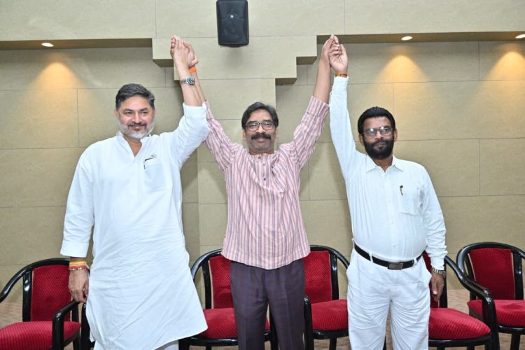 Chief Minister Hemant Soren raising the hands of INDIA Alliance candidates to show unity ahead of the Jharkhand Rajya Sabha Election 2026.